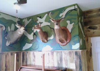 camo wallpaper with mounted deer decor