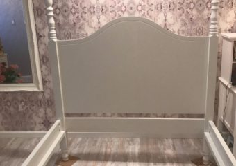 child's white bed and purple wallpapered walls