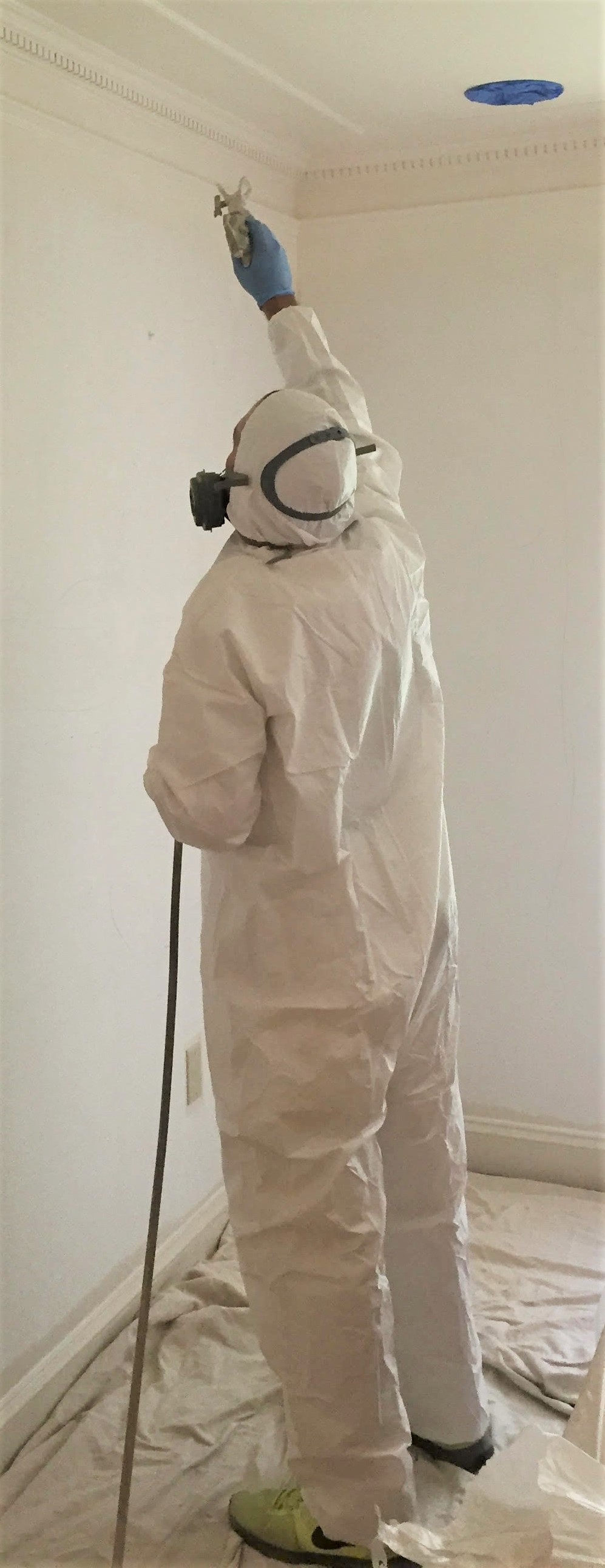 employee spray painting trim white
