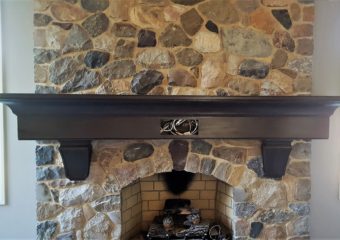 stone fireplace with dark brown wooden mantle