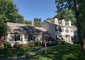 cream home exterior with green shutters