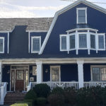 blue home exterior with wooden door